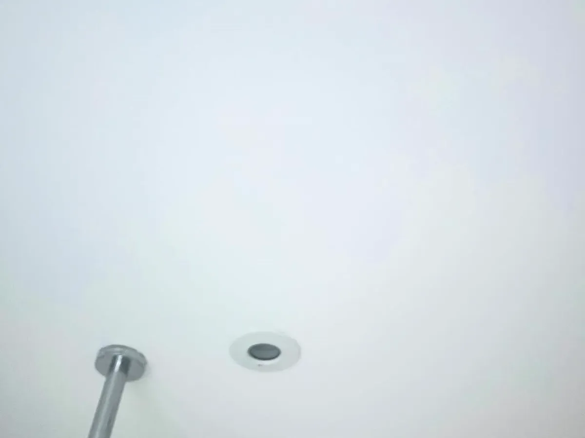 Freshly painted, smooth white bathroom ceiling after repair