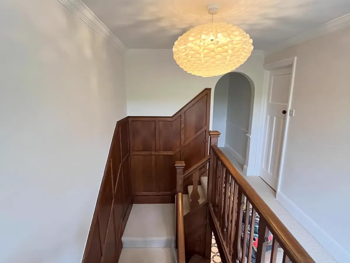 Landing and staircase after decorating, with a freshly painted white ceiling