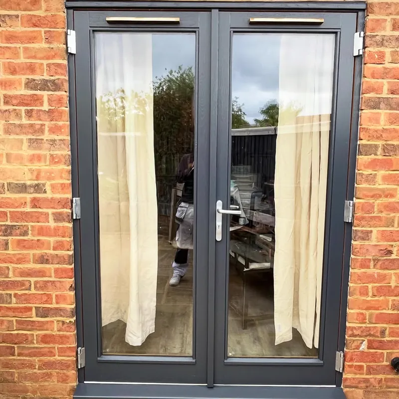 Anthracite-grey French doors set in a red-brick exterior
