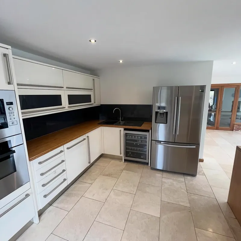 Modern kitchen with white units and a dark worktop