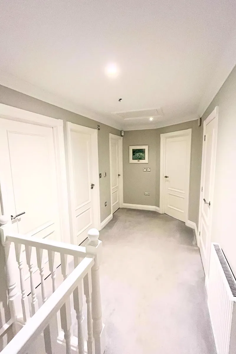 Landing with soft grey walls and a white spindle banister