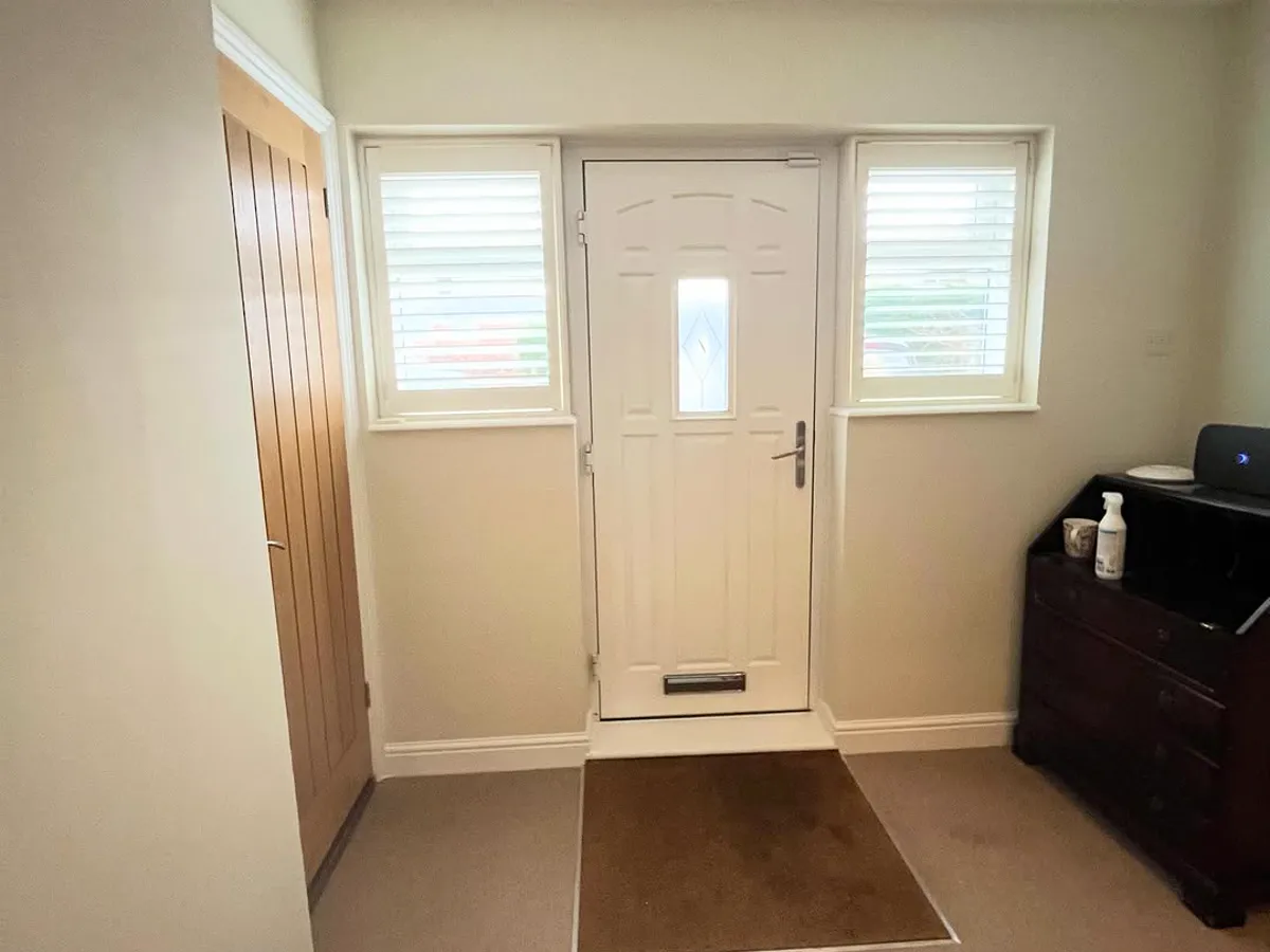 Finished entrance hall with a white composite front door and neutral walls