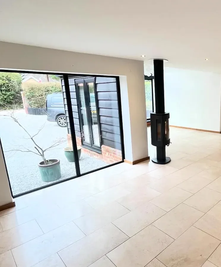 Finished open-plan kitchen and diner with white walls and bi-fold doors