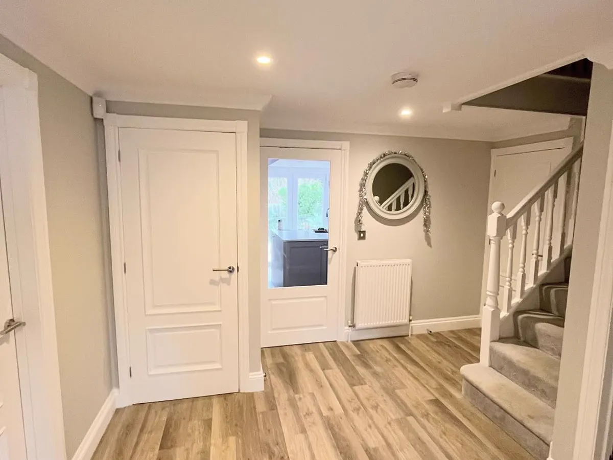 Finished landing with white-painted doors, a spindle staircase and wood-effect floor